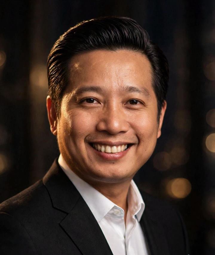 Anh Đặng Minh Tùng mỉm cười, mặc vest đen